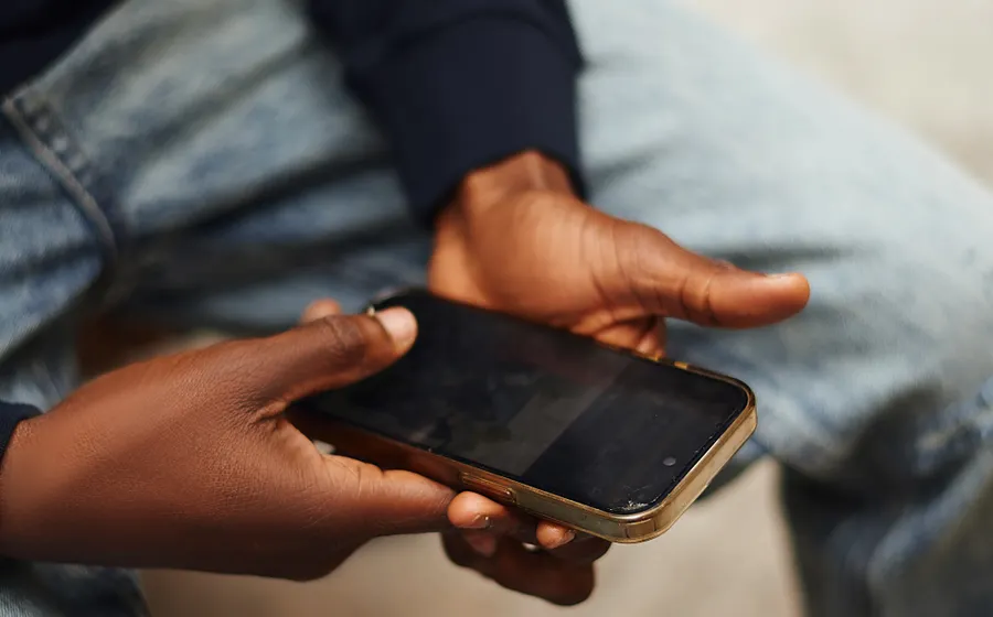 Hands holding a smartphone while signing up for a betting account